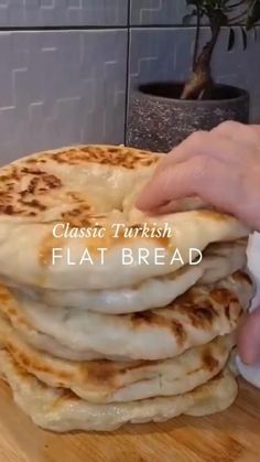 a stack of flat bread sitting on top of a wooden table