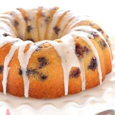 a blueberry bunt cake with icing on a white plate