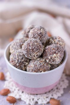 a white bowl filled with almonds sitting on top of a doily covered table