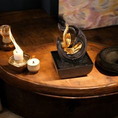 a wooden table topped with candles and a statue