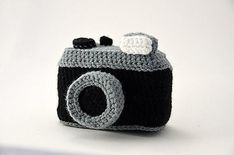 a crocheted camera is shown in front of a white background