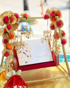 a red and gold frame with jewelry hanging from it's sides on a table