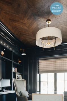 an office with black walls and wood paneling on the ceiling, along with two chairs