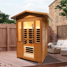 a small wooden sauna sitting on top of a deck next to a white couch