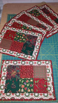 three quilted placemats sitting on top of a cutting board