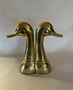 two brass ducks are standing next to each other