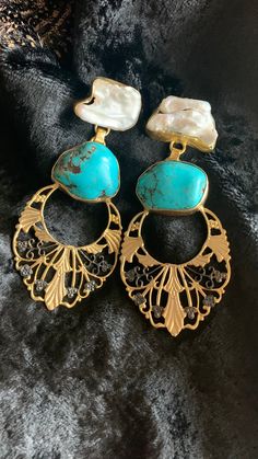 Simply Stylish and Elegant! A gorgeous pair of earrings for the gemstones lovers! Purely handmade with love by our skilled Indian craftsmen from Jaipur Length of earrings: 8.6 cms Width of earrings: 4 cms Handcrafted in brass with a gold plated base and natural gemstones. Turquoise and Baroque Pearls Notice a little rhodium plating on the gold plated base at the bottom. The stones used in the earrings are raw and hence have natural variations Note : Since Shivka's Jewellery is purely handmade by Stylish Earrings, Stylish Earring, Local Artisans, Earrings Collection, Pearl Drop, Baroque Pearls, Designer Earrings, Gemstone Earrings, Amazing Jewelry