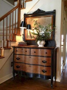 a wooden dresser sitting under a stair case