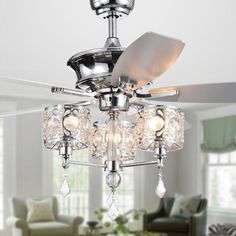 a ceiling fan with crystal chandelier hanging from it's blades in a living room