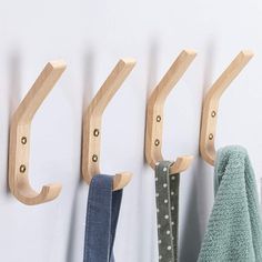 three wooden hooks are hanging on the wall