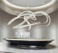 an artistic sculpture in the middle of a circular room with white walls and ceiling lights