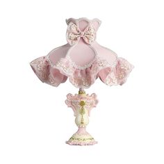 a pink and white lamp with a bow on it's top sitting on a table