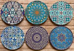 four decorative plates sitting on top of a wooden table