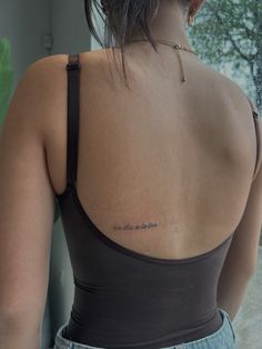 the back of a woman's shoulder with an inscription on it that reads,