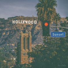 the hollywood sign is on top of a building near a traffic light and palm trees