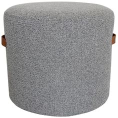 a large grey ottoman with wooden legs and buttons on the top, sitting in front of a white background