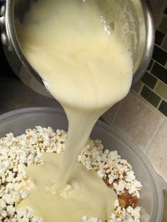 a bowl filled with popcorn and milk being poured into it