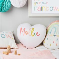 two heart shaped balloons sitting on top of a bed next to pillows and other decorations