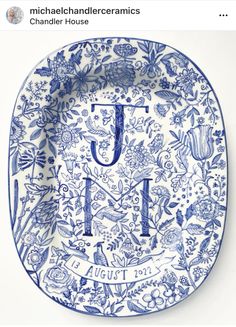 a blue and white plate with the letter j on it, surrounded by floral designs