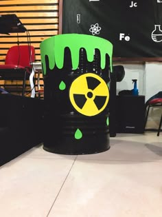 a green and black trash can with a radioactive sign on it