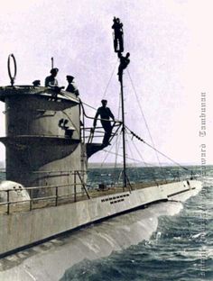 an old black and white photo of a boat in the water with men on it