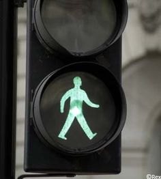 a traffic light with a green pedestrian crossing signal on it's left hand side