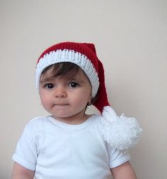 a baby wearing a red and white santa hat