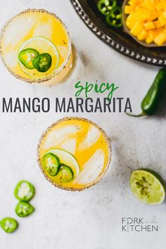 two glasses filled with mango margarita next to sliced jalapenos