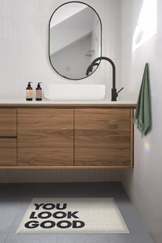 a bathroom with a sink, mirror and rug on the floor