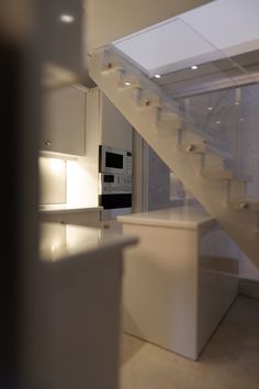 an empty kitchen with stairs leading up to the upper floor