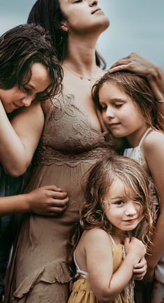 three women and two children are posing for the camera