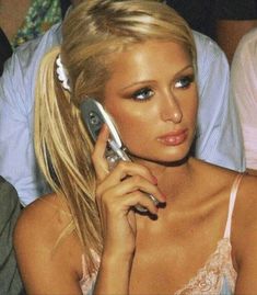 a woman talking on a cell phone while sitting in front of other people at a party