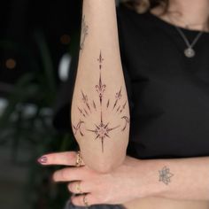 a woman's arm with an arrow tattoo on it