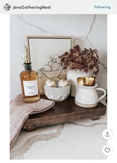 a bottle of perfume sitting on top of a wooden table next to other bottles and vases