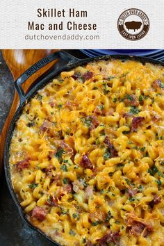 a skillet filled with macaroni and cheese on top of a wooden table