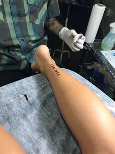 a man getting a tattoo on his leg