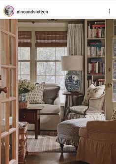 a living room filled with furniture next to a window covered in bookshelves and windows