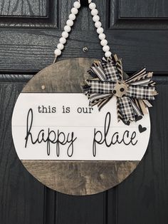 this is our happy place sign hanging on the front door with bead necklaces