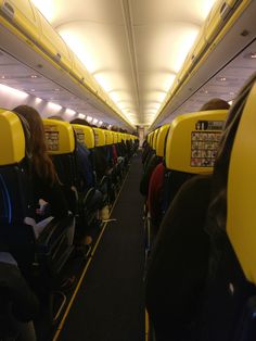 people sitting on seats in an airplane with their backs turned to the side as they look down