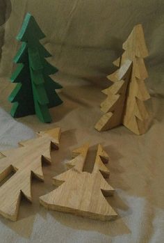 three wooden christmas trees are on the table