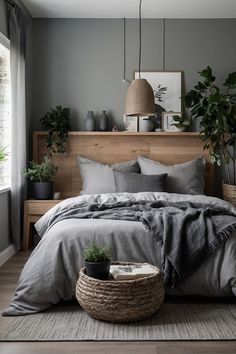 a bedroom with grey walls and bedding, potted plants on the nightstands