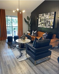 a living room filled with furniture next to a large glass window and wooden flooring