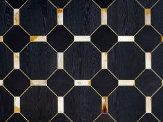 a black and gold tiled wall with wooden squares in the center, as well as other wood panels