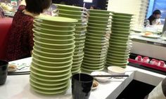 stacks of green plates sitting on top of a white table