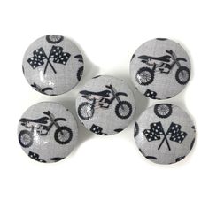 four buttons with black and white designs on them, one has a bike in the middle