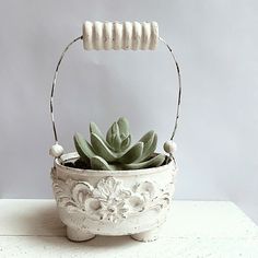 a small white planter with succulents in it