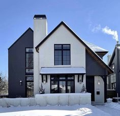 a house with snow on the ground in front of it