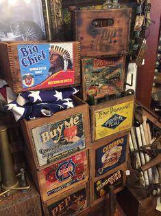 several wooden boxes stacked on top of each other in front of a wall with posters