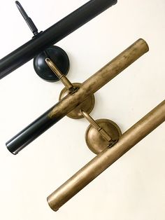 an old fashioned brass wall light with two black lamps on it's back side