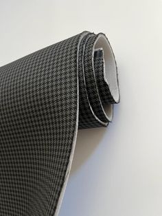 a black and white tie laying on top of a white table next to a wall